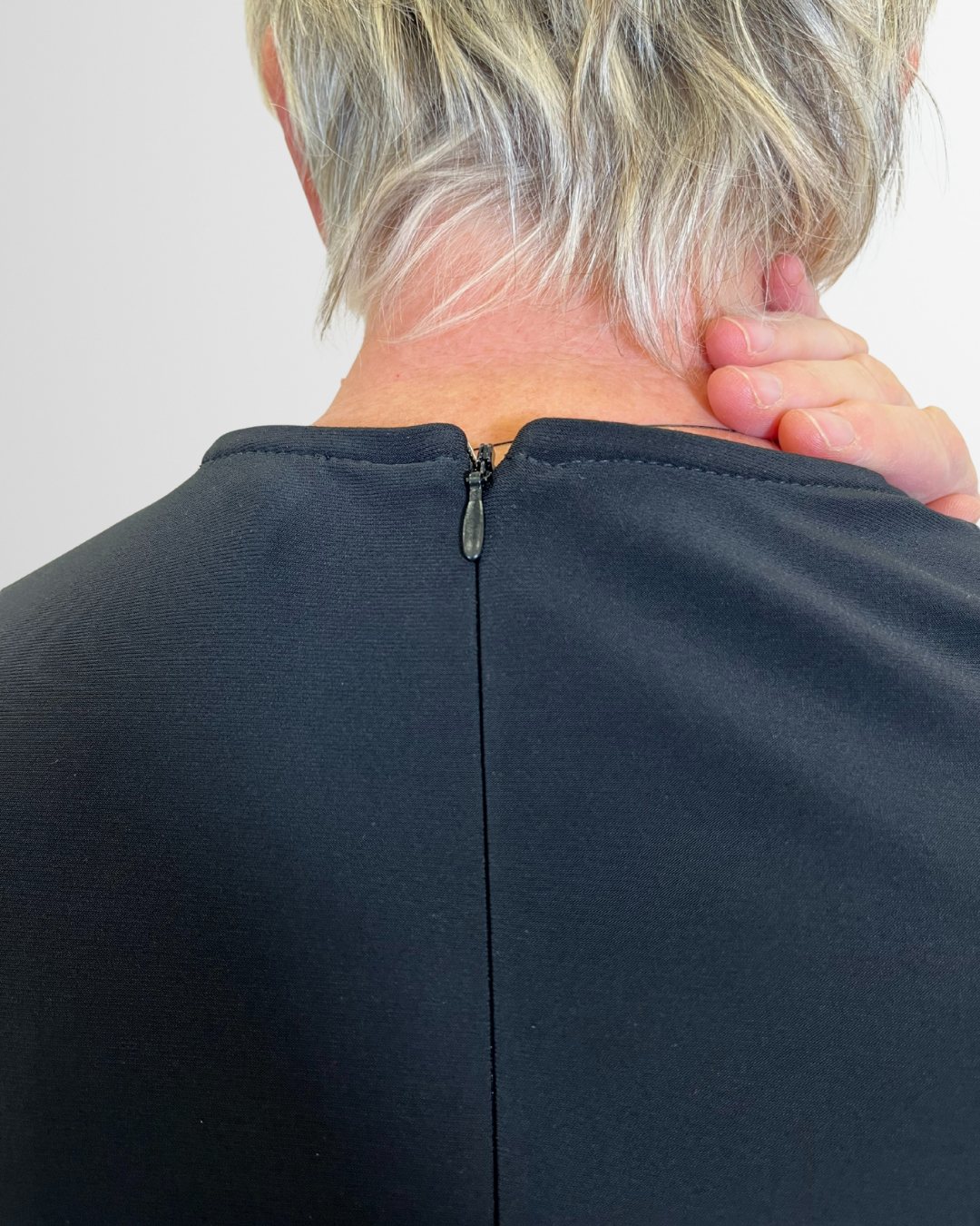 Abito nero con incrocio e dettaglio oro